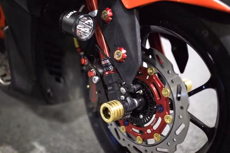 Ở phía trước, hệ thống phanh của xe được nâng cấp với đĩa phanh kiểng Boushi Thái Lan cùng heo Brembo Billet 4 pis, nhưng vẫn giữ được ABS. Vỏ phuộc trước nguyên bản của xe đã được thay bằng vỏ Trusty cứng cáp hơn, đồng thời chiếc NVX 155 còn có thêm đèn LED L4 chiếu sáng tăng cường của Tun.