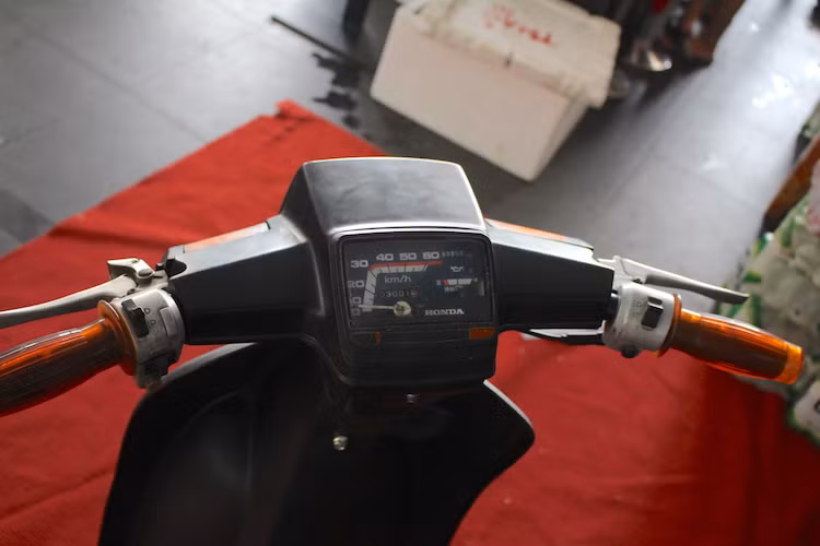 Không chỉ có phần đầu trước, bảng đồng hồ của SH50 cũng được thiết kế với các vạch báo tốc độ và phông chữ gần như y hệt so với Cub 82. Chưa dừng lại ở đó, các cùm công tắc hai bên của chiếc xe cũng rất giống những đời Super Cub, với điểm khác biệt chỉ là cùm trái được tích hợp thêm tay phanh.