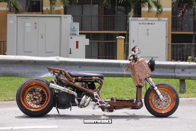 Đáp ứng nhu cầu của các dân chơi, có rất nhiều xưởng độ chuyên "dọn kiểng" Zoomer tại Mỹ, một trong số đó là Dorbyworks. Mới đây, xưởng độ này vừa hoàn thành xong một chiếc Zoomer độ low rider cực độc đáo, được trang trí theo phong cách steampunk gợi nhớ về những cỗ máy làm bằng đồng hoặc chạy hơi nước cổ điển.