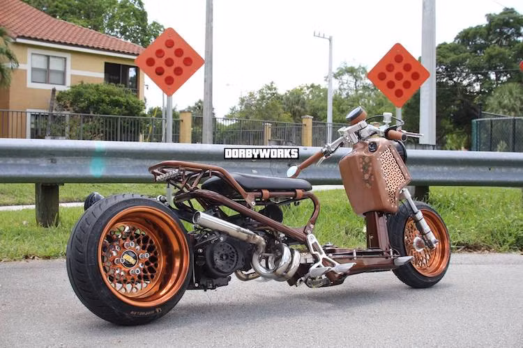 Chiếc xe tay ga Honda Zoomer với kiểu dáng "trần trụi" cá tính đã được xưởng Dorbyworks độ lại theo phong cách low rider Mỹ, với điểm nhấn là các chi tiết trang trí "siêu dị" kiểu cổ điển. Ước tính, một chiếc xe ga Zoomer độ tương tự như thế này có chi phí lên tới khoảng 7000 USD (tương đương 158 triệu đồng).