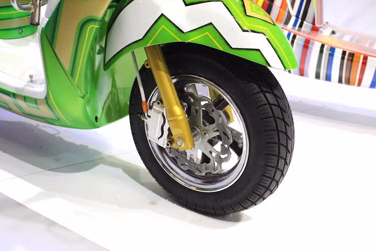 Bộ mâm đúc 6 cánh đơn nguyên bản của Grande đã được thay bằng cặp mâm độ 5 cánh mạ chrome bóng lộn. Ở phía trước, cặp phuộc nguyên bản của xe nay có màu xanh lá mờ nổi bật. Trong khi đó, hệ thống phanh trước đã được độ lại bới đĩa kiểng và heo Adelin 4 piston monoblock, kết hợp với pad nhôm CNC cũng của Adelin.