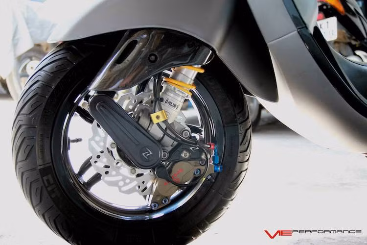 "Dàn chân" trước của chiếc Sprint vẫn giữ nguyên mâm 5 cánh 12 inch nguyên bản, nhưng đã được độ lại khá "khủng" với phuộc Ohlins cùng hệ thống phanh gồm đĩa Braking và heo Brembo 2 pis billet. Một số chi tiết "kiểng" như chắn phuộc bằng sợi carbon và ốp "giò gà" Zelioni tạo thêm điểm nhấn cho bánh trước xe.