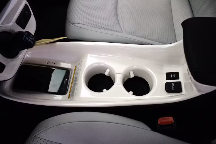 Nằm ở bệ trung tâm, Prius được trang bị 2 khay đựng cốc cùng cổng USB và ổ điện 12V/120W. Nằm phía trên là đế sạc điện thoại không dây, hỗ trợ một số loại điện thoại có chức năng sạc không dây theo chuẩn Qi của Samsung, Nokia, Microsoft... Cần số của xe có kích thước nhỏ và nằm trên bảng điều khiển trung tâm.