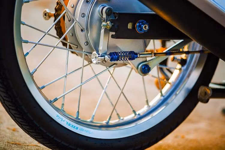 Ở thế hệ đầu tiên, Exciter vẫn sử dụng bánh căm như nhiều mẫu xe số phổ thông khác. Trên bản độ này, chủ xe đã thay cặp niềng nguyên bản bằng niềng nhôm Excel nhẹ và sắc sảo hơn. Phanh sau của xe vẫn giữ nguyên phanh đùm, nhưng có một số chi tiết nhôm CNC và màu ánh titan đẹp mắt hơn.