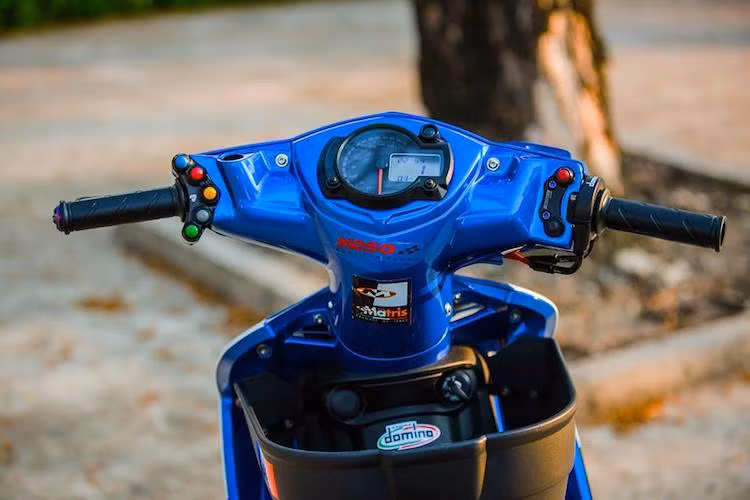 Nằm ở phía trên tay lái, cụm đồng hồ điện tử Koso RX2N đã được chế mủ khéo léo vào phần nhựa gáy của chiếc Exciter. Trong khi đó, hai bên tay lái là cùm công tắc rút gọn Ducati và cùm ga cuốn Domino.