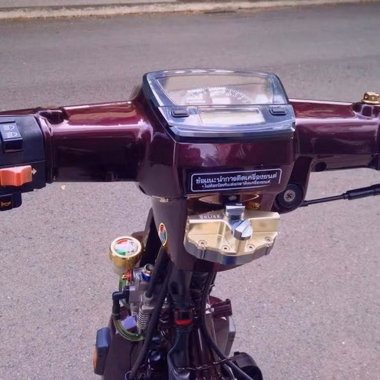 Tổng phanh của chiếc xe đã được giấu gọn ở bên cạnh cổ nhờ sử dụng pen dầu lấy từ Honda Vision, khiến phần đầu nguyên bản của chiếc Dream không cần phải khoét lỗ lắp bình dầu. Tuy nhiên, nhựa gáy của chiếc xe đã được khoét lỗ khéo léo để gắn trợ lực trung tâm Ohlins, phía trên là bảng đồng hồ điện tử Uma Racing dành riêng cho Dream.