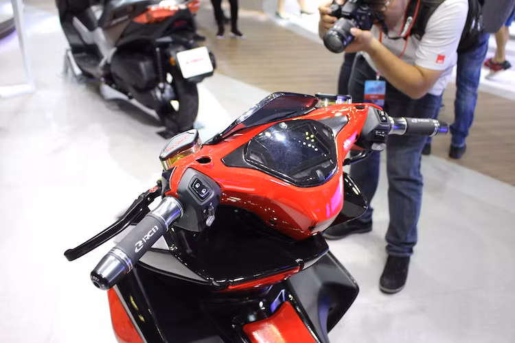 Đồng hồ điện tử full màn hình LCD màu xanh là điểm đặc trưng của dòng NVX, chính vì vậy Yamaha đã giữ lại chi tiết này trên bản độ. Hai bên tay lái của xe là sự xuất hiện của cặp bao tay Racing Boy và cùm phanh Brembo đồ chơi với bình dầu tích hợp.