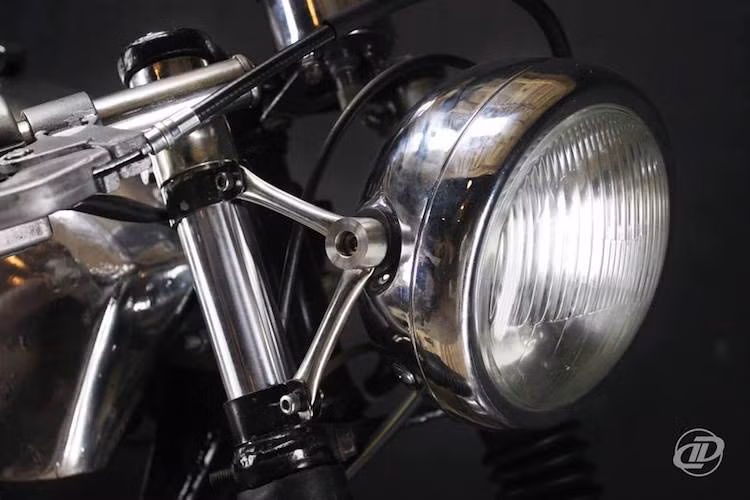 Ở phía trước, dàn đầu của chiếc xe đã được thay cặp phuộc mới nhưng vẫn giữ lại bánh căm 18 inch nguyên bản của Minsk. Nằm phía trên phuộc là đèn pha chóa tròn cổ điển được mạ bóng và gắn với phuộc xe thông qua cặp tai bắt với thiết kế mảnh khảnh, thanh lịch.