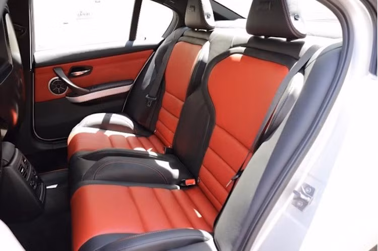 Không chỉ có ghế trước, hàng ghế sau của chiếc xe cũng có kiểu thể thao ôm lưng. Nội thất của xe được bọc kết hợp giữa 2 tông màu đen và đỏ tươi Melbourne, đồng thời một tấm bảng nhỏ gắn trong cabin cũng khẳng định sự đặc biệt của M3 CRT.