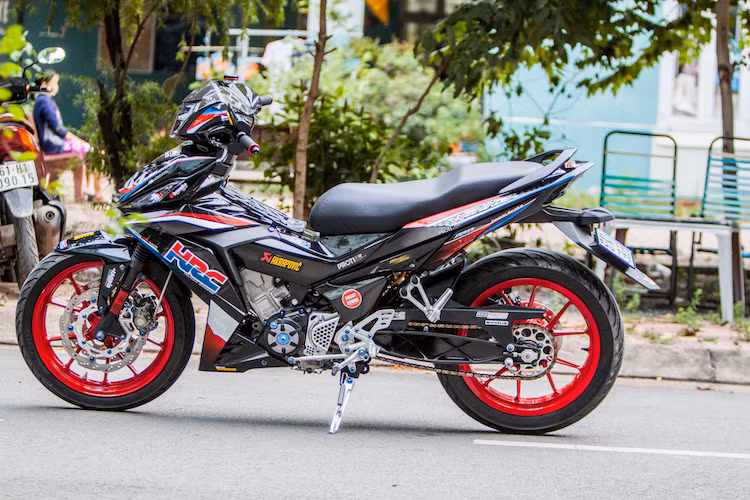 Dàn vỏ bóng nguyên bản của Winner 150 đã được chủ xe đặt xưởng ABMiracle sơn tem đấu HRC nổi bật trên nền màu đen. Trong khi đó, một số chi tiết nhựa nhám đã được dán sợi carbon thật, khiến chiếc xe càng trở nên thể thao hơn.