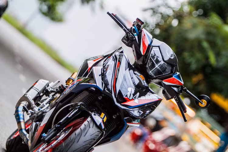 Ngày càng có nhiều bản độ đẹp mắt được biker Việt tạo ra từ Honda Winner, khiến dòng xe này càng trở nên hấp dẫn hơn. Bằng cách trang trí lại dàn vỏ và độ lại "dàn chân" lấy từ mẫu xe phân khối lớn "hạng nhẹ" KTM RC 390, một biker An Giang đã có chiếc Winner "ngầu" hơn và không "đụng hàng" với bất kỳ chiếc xe nào khác.