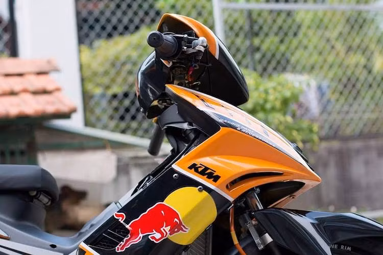 Dù là một chiếc xe Yamaha, nhưng chiếc Exciter 135 đã được chủ xe sơn airbrush toàn bộ trong tông màu quen thuộc cam-đen của đội đua KTM Red Bull Factory Racing tại nhiều giải đua khác nhau. Dàn áo phong cách xe đua đã khiến chiếc xe trở nên nổi bật và "chiến" hơn.