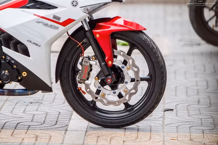 Ở phía trước, mâm 5 cánh kép nguyên bản của Exciter đã được thay thế bởi mâm 5 cây từ Honda NSR150SP. Trong khi đó, hệ thống phanh trước đã được độ lại khá "khủng" với đĩa Galfer lòng nhôm CNC và heo Brembo HP.