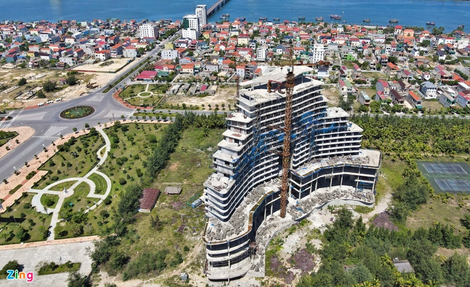 Xung quanh khối tòa nhà khách sạn, các tấm lưới đan ngăn đất đá, vật liệu rơi vãi đã rách tơi tả và rụng gần hết, chỉ còn trơ lại các khung kim loại dùng để cố định các tấm lưới vào tòa nhà. (Ảnh: Zing).