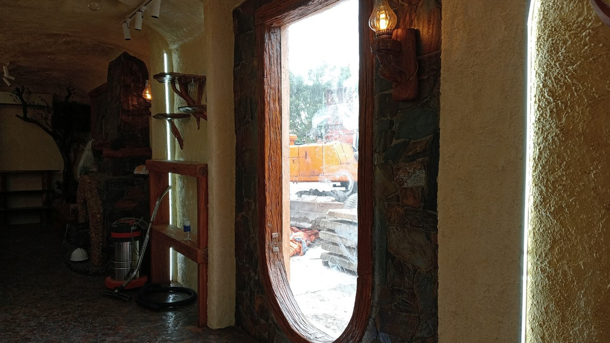 Từng chi tiết bên trong ngôi nhà được thiết kế vô cùng tỉ mỉ. Gian chính giữa nhà được đặt bộ bàn ghế bằng gỗ đồ sộ. Tiếp đến là lò sưởi và các vách tường được trang trí bằng những bức tranh vẽ bằng vữa và nhiều chất liệu khác.