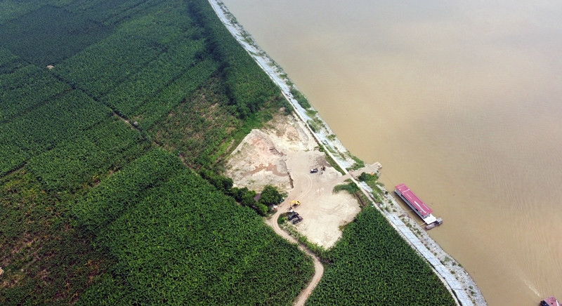 Xe tải, máy xúc hoạt động bên trong bãi tập kết nằm khuất giữa cánh đồng này rất nhộn nhịp.