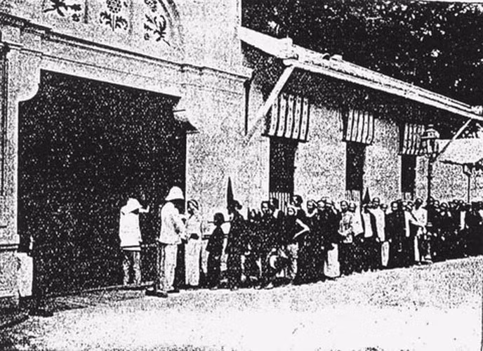 Công nhân tan ca ra về, được kiểm tra tại cổng sau của nhà máy.