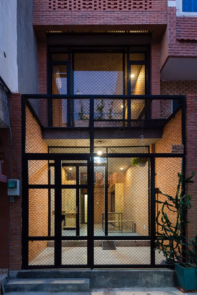 Ngôi nhà tràn ngập ánh sáng mặt trời với kính trên mái nhà và tường gạch lỗ.