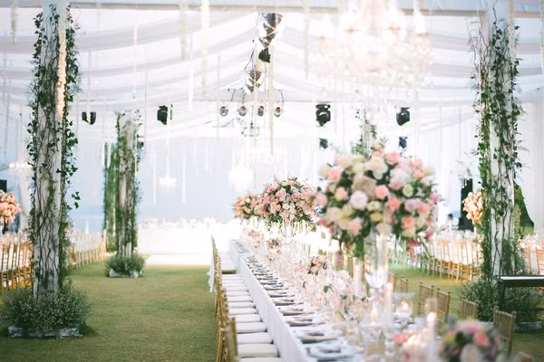 Trong buổi tiệc tối, bàn tiệc dài hướng biển được trang trí bởi các trụ hoa tươi theo thông màu pastel chủ đạo xuyên suốt đám cưới.