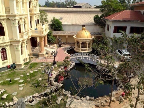 Khuôn viên trước nhà rộng rãi với hồ nước, cầu đá hợp phong thủy.