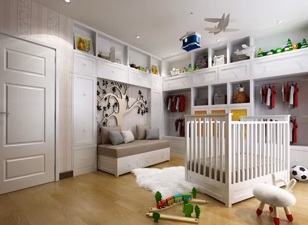 Vợ chồng Ngọc Thạch chuẩn bị phòng ngủ sang trọng cho con trai trước khi ra đời. Không gian riêng của Ricky được bố mẹ chọn màu ghi và trắng nhẹ nhàng, dịu mắt. Tủ quần áo và kệ trang trí được đặt ốp vào tường để tiết kiệm diện tích. Giường cũi và đồ chơi của bé đa phần đều bằng gỗ.