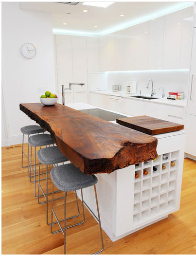 Kiểu bàn gỗ độc đáo nổi bật trên nền tường và tủ bếp trắng tinh khôi.