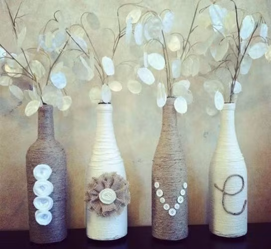 Với những chai bia, chai thủy tinh không dùng đến, bạn hãy khéo léo cuốn len xung quanh để tạo thành những lọ cắm hoa trang trí nhà tuyệt đẹp thế này.
