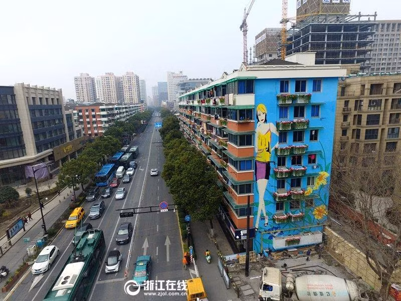 Cô gái sexy trên bức tường nhà thu hút ánh nhìn người qua đường.