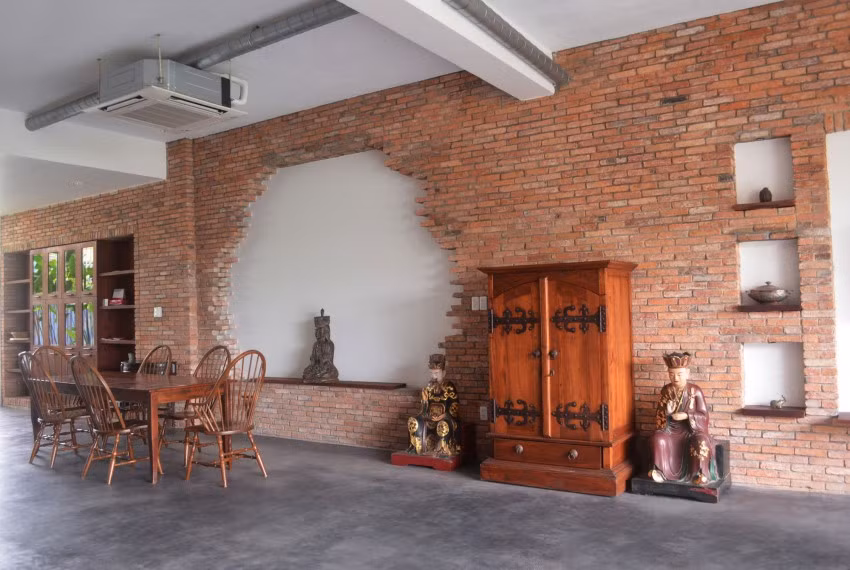 Sử dụng vật liệu tự nhiên như gỗ, gạch cũ và không gian xanh, ngôi nhà trở thành không gian sống không có giới hạn.