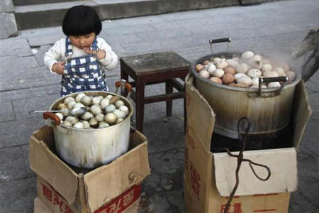 Gánh hàng bán món trứng luộc nước tiểu trên vỉa hè một con phố tại thành phố Đông Dương, tỉnh Chiết Giang, Trung Quốc. Trứng luộc nước tiểu có giá khoảng 1,5 NDT/quả, gần gấp đôi một quả trứng bình thường.