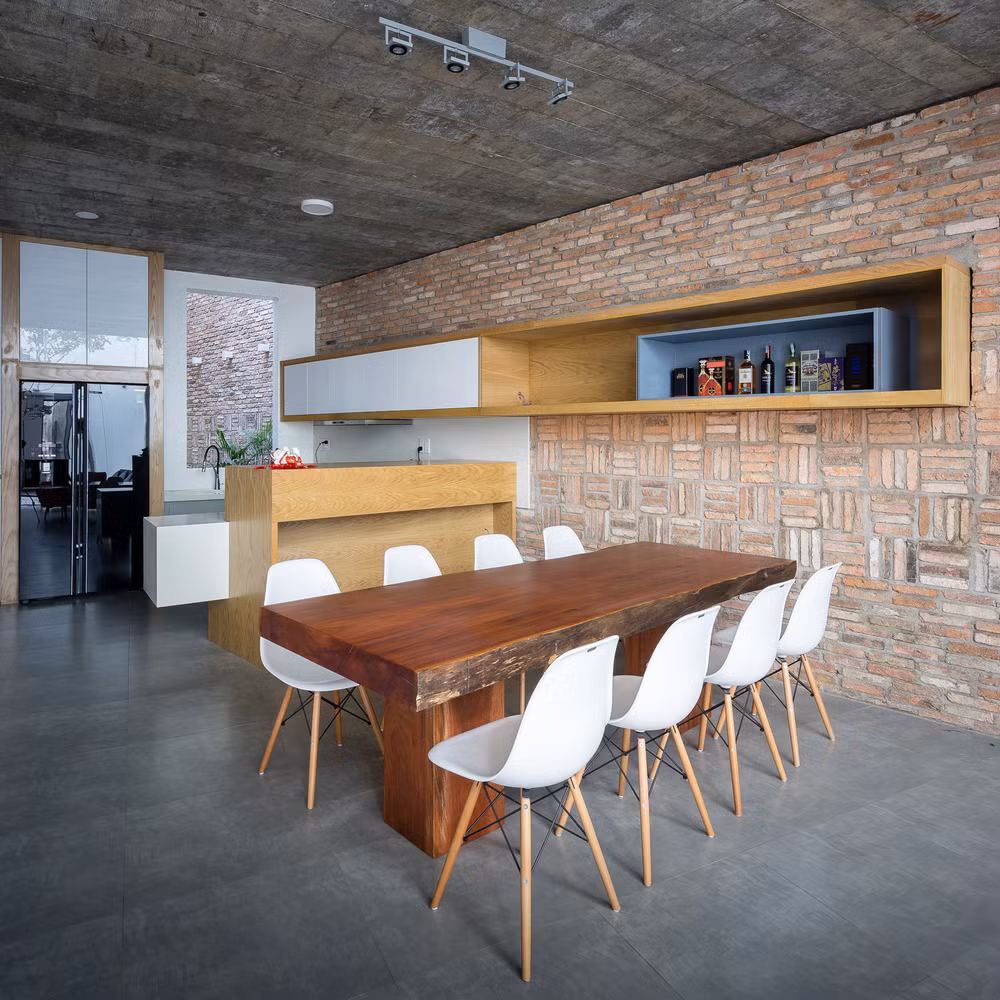 Khu bàn ăn hiện đại và tinh tế nổi bật bên mảng tường gạch thô.
