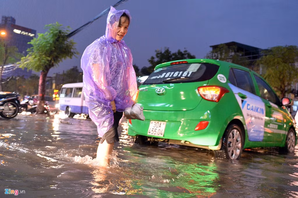 Khi mưa đã tạnh, nước rút khá nhiều, những người đi bộ trên vỉa hè, đến đoạn đầu ngõ 165 vẫn phải tháo giầy để lội qua.