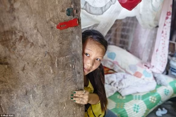 Xiao Jie 13 tuổi kết hôn cùng chồng 18 tuổi sau 3 ngày gặp gỡ. Giờ họ cũng ở nhà chồng. Bố mẹ Wen phải đi làm cách xa hàng ngàn cây số và đều đặn mỗi tháng gửi tiền về trợ giúp hai vợ chồng “trẻ con”. Jie đang nhìn ra từ phòng ngủ tại làng Vạn Hà, tỉnh Vân Nam.