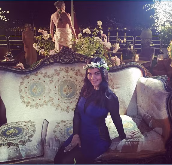 Nữ diễn viên Sheila Shah đội vương miện hoa (món đồ có sẵn cho tất cả mọi người). Chiếc du thuyền được trang hoàng bởi rất nhiều cây xanh và hoa lộng lẫy.