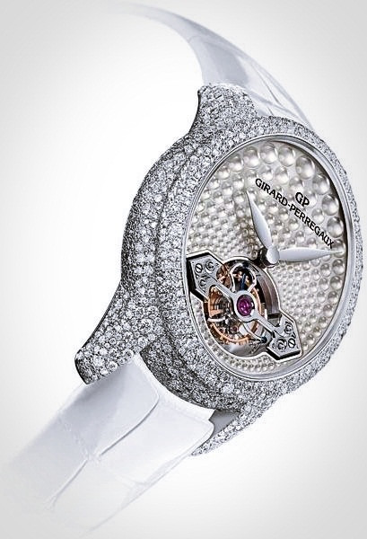 Chiếc đồng hồ Girard-Perregaux Cat’s Eye Tourbillon Haute Joaillerie có mặt hình bầu dục với các kim được chạm khắc rất tinh xảo. Vỏ ngoài được làm bằng vàng trắng có gắn tới 1000 viên kim cương rực rỡ trong khi nút điều chỉnh ngày giờ được gắn một viên kim cương hồng. Dây đeo đồng hồ được làm bằng da cá sấu màu trắng tinh tế.