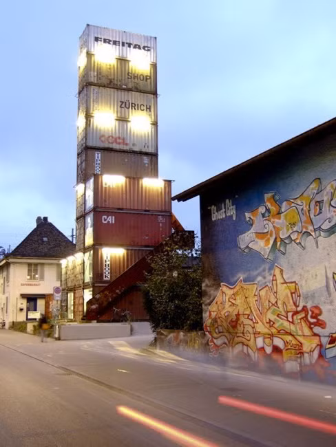 Công ty Freitag của Thụy Sĩ đã tạo ra một vài chiếc túi thời trang được làm từ những nguyên liệu tái chế trong cửa hàng này. Vào năm 2006, anh em nhà Freitag đã xây dựng cửa hàng thân thiện với môi trường từ 17 chiếc container cũ. Ở độ cao 26m, khách hàng có thể quan sát mọi thứ từ trên cao.