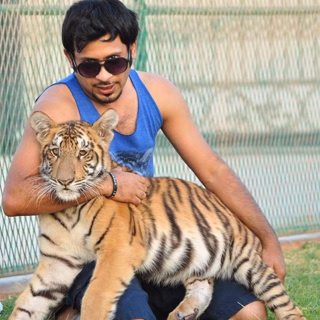 Vị đại gia bế một con hổ trong bộ sưu tập mãnh thú của mình.