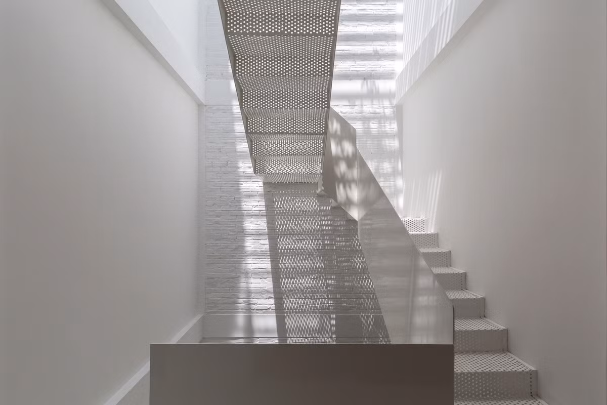 Cầu thang tầng 3 được thiết kế dạng lỗ để ánh sáng len lỏi tới từng góc tối.