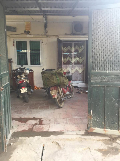 Mặt ngoài của ngôi nhà cấp 4 được che chắn bởi chiếc cổng sắt đã hoen gỉ.