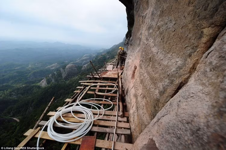 Công việc thót tim của những người công nhân xây dựng vẫn diễn ra hàng ngày trên những giàn giáo bằng gỗ rộng hơn 3m, cheo leo trên vách núi.