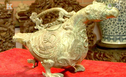 Đặc biệt, loạt sản phẩm ấn tượng nhất trong bộ sưu tập của ông là các bảo vật đời Thương - Chu, có niên đại cách đây khoảng 5.000 năm. Trong số đó phải kể đến chiếc ấm uống rượu hình còn vịt. Chiếc ấm này có quai hình con rồng, phía trên nắp có gắn xích. Một số thương gia người Đài Loan nghe tiếng tìm đến và trả giá lên tới hàng triệu USD để mua "báu vật" này, nhưng ông Hiến từ chối. Ảnh: Khám Phá.