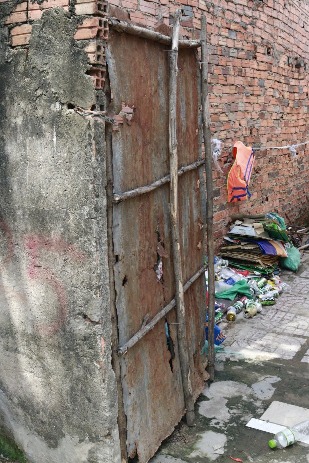 Cổng vào dãy trọ giá rẻ là một tấm tôn đã lủng lỗ và han gỉ, chỉ cần tác động nhẹ cũng có thể rơi ra bất cứ lúc nào.