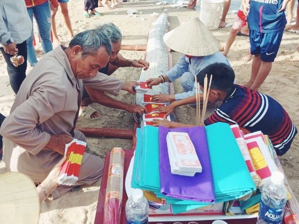 Người dân xã Hải Trạch, huyện Bố Trạch, tỉnh Quảng Bình làm lễ cúng và an táng cá hố rồng theo tập tục địa phương. (Ảnh: Võ Dung/TTXVN)