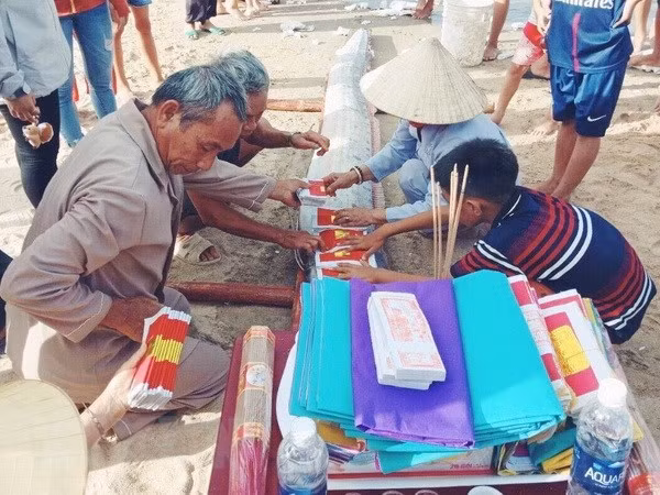 Người dân xã Hải Trạch, huyện Bố Trạch, tỉnh Quảng Bình làm lễ cúng và an táng cá hố rồng theo tập tục địa phương. (Ảnh: Võ Dung/TTXVN)