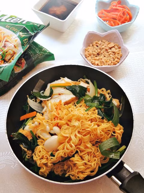 Tiếp đó, cho một chút dầu vào mì trộn đều. Đun nóng chảo, cho chút dầu ăn và phi tỏi thơm thì cho thịt đã ướp vào để xào. Khi thịt đã săn lại thì cho nước tương và cà chua băm vào xào và nêm nếm gia vị cho vừa ăn. Bạn hãy xào mì tới khi nước sốt đã sệt lại thì cho thêm hành lá và ớt sợi. Nguồn ảnh: Pinterest, Vào bếp.