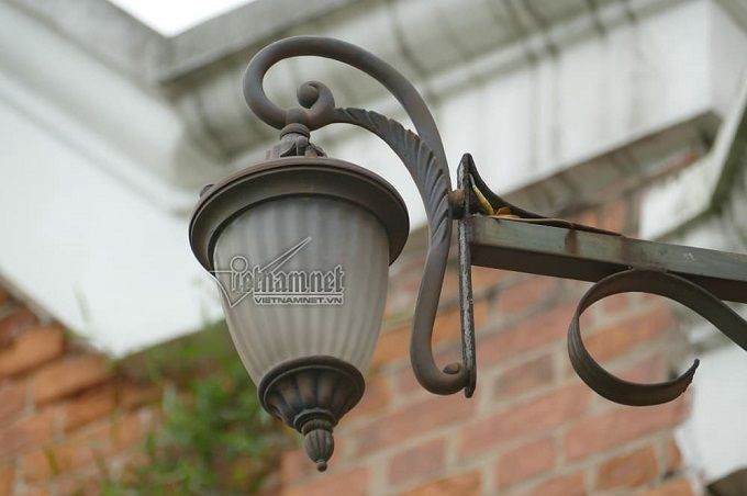 Đèn chiếu sáng làm từ đồng, chụp đèn bằng thủy tinh. Đây là một trong những chi tiết trang trí, giúp dinh thự đẹp mắt hơn. Đặc biệt là vào ban đêm.