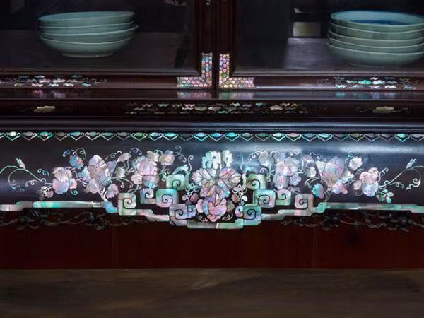 Những mảnh ghép từ vỏ của con trai với những màu sắc óng ánh tạo nên vẻ đẹp rất đặc biệt cho tủ chè.