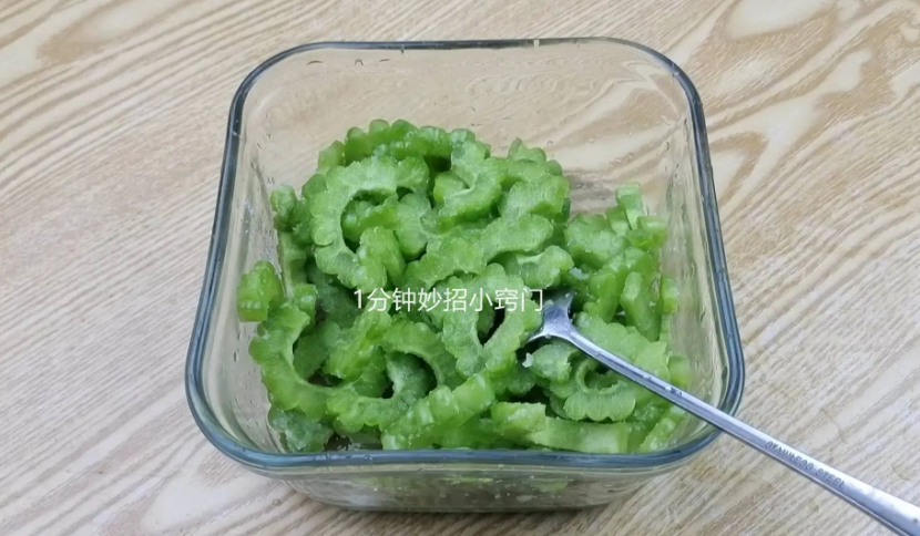 Tiếp tục thái mướp đắng thành những lát mỏng cho vào bát, rắc muối ăn vào, đảo đều rồi ướp trong 10 phút. Mục đích của việc này là để nước đắng trong khổ qua ngấm ra ngoài.