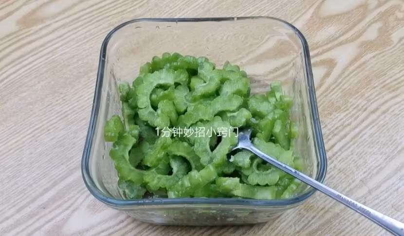 Tiếp tục thái mướp đắng thành những lát mỏng cho vào bát, rắc muối ăn vào, đảo đều rồi ướp trong 10 phút. Mục đích của việc này là để nước đắng trong khổ qua ngấm ra ngoài.