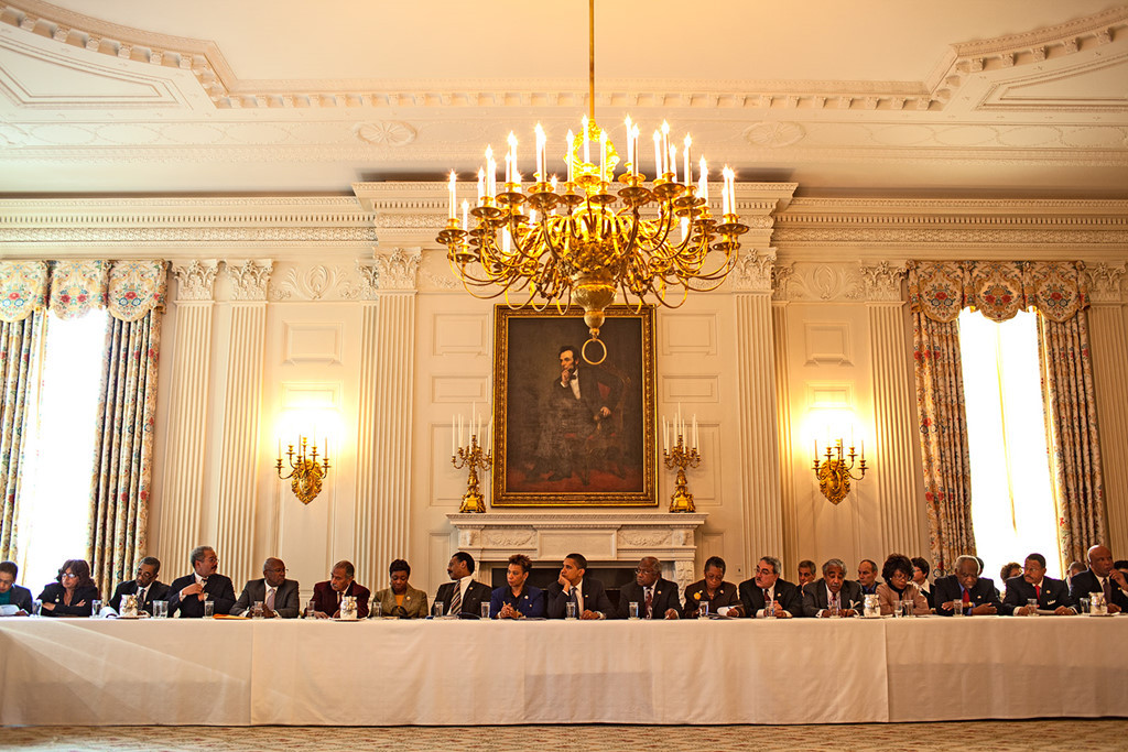 Ông Obama lắng nghe nhóm nghị sĩ da màu trong cuộc gặp tại Phòng Quốc yến Nhà Trắng vào ngày 26/2/2009. Dáng vẻ của ông tương tự cố tổng thống Abraham Lincoln, người trong bức tranh treo trên tường phía sau lưng ông.